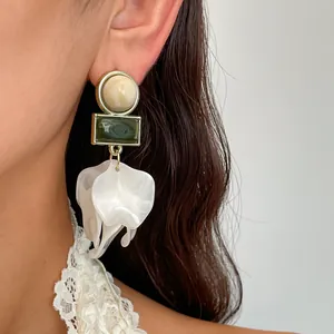 Detaillierte Nahaufnahme von Vintage-Ohrringen mit weißen Acryl-Blütenblättern am Ohr