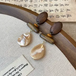Detail shot of Neo-Chinese style vintage wooden earrings with iridescent shell drop pendants