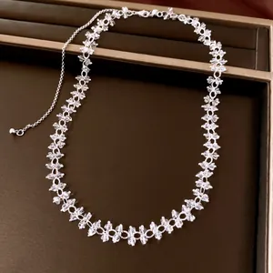 Detailed view of an elegant silver crystal beaded choker necklace on a brown tray
