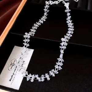 Detailed macro view of an elegant clear crystal beaded cluster necklace in a black velvet display