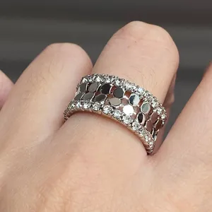 Vue détaillée d'une bague en nid d'abeille argentée avec bordure sertie de zircones brillants.