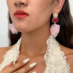 Detailaufnahme der rosa Acryl Blütenblatt Quasten Ohrringe im Vintage-Stil am Modell