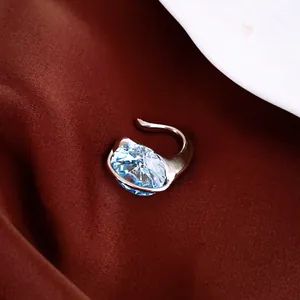 Nahaufnahme der funkelnden ovalen blauen Zirkon-Ohrmanschette in Silber