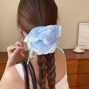 Gedetailleerde weergave van een blauw geruite scrunchie met elegante witte kantrand