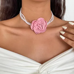 Detail view of a vintage pink fabric rose multi-strand pearl choker necklace for women