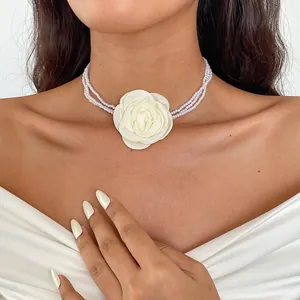 Detailed view of vintage multi-strand pearl choker featuring a large cream fabric rose