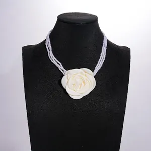 Detailed view of vintage multi-strand pearl necklace with cream fabric rose flower