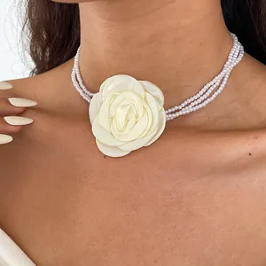 Detailed shot of a multi-layer pearl choker necklace featuring a large cream fabric rose