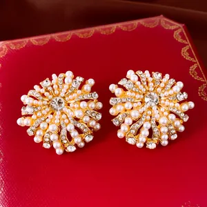 Detailopname van elegante bloem oorknopjes met parels en strass op een luxe rode doos.