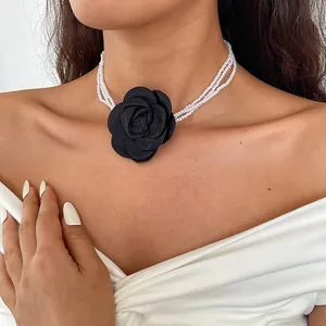 Detail of vintage multi-layer pearl choker with black fabric camellia flower adornment
