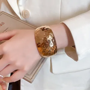 Detailed macro view showing the hammered gold finish on this wide resin cuff bracelet