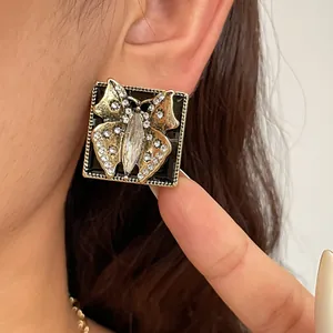 Close-up of vintage butterfly stud earring with sparkling rhinestones and black enamel