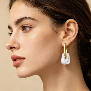Elegant gold-plated geometric hoop earrings featuring a marble-pattern resin pendant.
