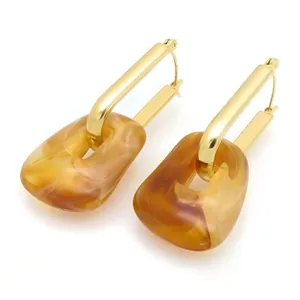 Modern geometric paperclip earrings with gold-plated finish and marbled resin blocks.