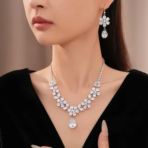 Nahaufnahme eines eleganten Sets aus Zirkonia-Halskette und Ohrringen mit Blumen