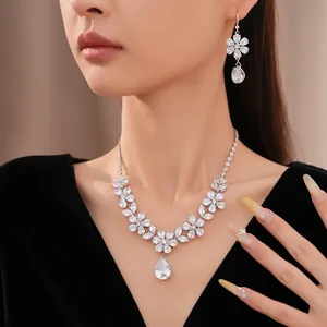 Elegante Nahaufnahme eines funkelnden Zirkon-Blumen- und Tropfen-Halsketten- und Ohrring-Sets Foto