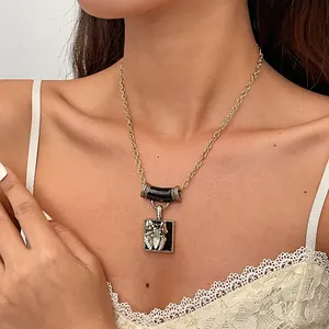 Detailed view of a vintage gold necklace featuring a rhinestone butterfly on black enamel.