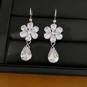 Detaillierte Nahaufnahme von funkelnden Zirkonia-Blumenohrringen auf schwarzem Display