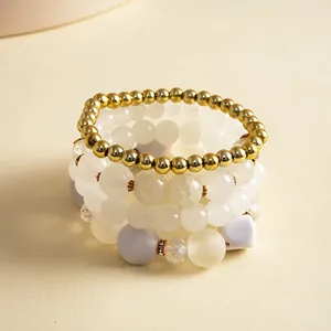 Dettaglio di un set di quattro bracciali vintage con perle dorate e grani in acrilico