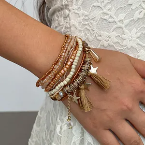 Vista dettagliata di braccialetti di perle multistrato boho con stelle dorate e nappe