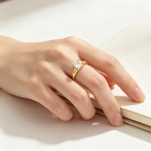 Detailansicht eines eleganten Goldrings mit quadratischem Stein an einer Hand