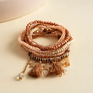 Vista dettagliata del bracciale di perle multistrato con nappe marroni e stelle