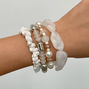 Vista dettagliata del set di quattro braccialetti retrò con perline bianche in acrilico e vetro