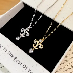 Gros plan de colliers en zircon plaqué or 14K avec fleur de lys et cœur cristal