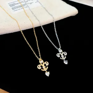 Gros plan des pendentifs fleur de lys avec cœurs en zircon en versions or et argent