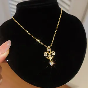 Vue macro détaillée d'un collier avec pendentif cœur en zircon fleur de lys en or 14K