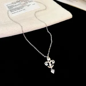 Gros plan détaillé du collier fleur de lys avec un pendentif en zircon étincelant en cœur