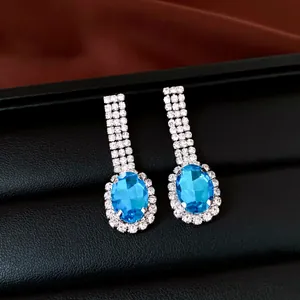 Detailansicht von silbernen Ohrhängern mit blauen Edelsteinen und Strasssteinen