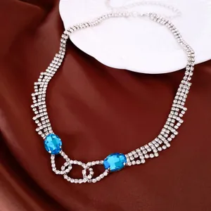 Detail einer eleganten Silberkette mit zwei großen blauen ovalen Strasssteinen für Feste