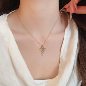 Gros plan d'un collier plaqué or 14K avec cœur en zircon et pendentif fleur de lys