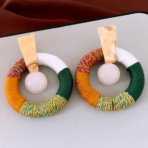 Boucles d'oreilles ethniques avec cordon en coton coloré et perle en résine élégante.