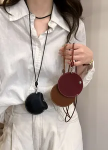 Detail shot of elegant circular leather pendant necklaces available in black, brown, and red colors.