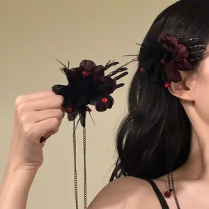 Close-up of gothic Halloween hair clip with dark flowers and skeletal hand tassels
