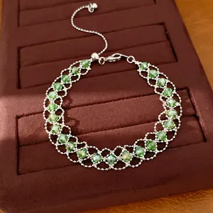 Gros plan du bracelet ajustable en perles de verre vertes tressées avec maille argentée