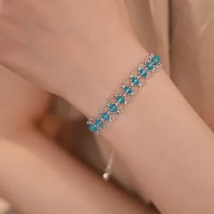 Gros plan d'un bracelet en maille tissée de perles de verre bleues et cordon réglable