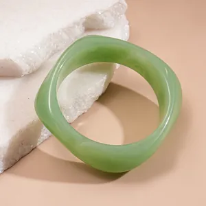 Detailed macro view of a translucent light green chunky resin bracelet on stone