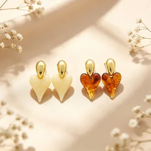 Elegant heart-shaped resin earrings in cream and amber with gold-plated finish