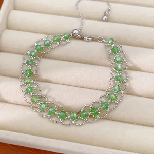 Vue détaillée d'un bracelet en maille tissée avec perles de verre vertes et chaîne réglable.