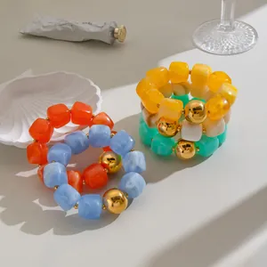 Bunte böhmische Armbänder mit geometrischen Harzblöcken und goldenen Perlen im Detail