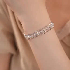 Gros plan détaillé d'un élégant bracelet en perles de verre tissées en treillis sur un poignet