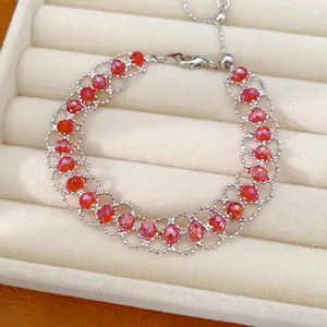 Détail d'un bracelet en perles de verre rouges tissées avec un fermoir réglable