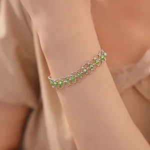 Gros plan élégant d'un bracelet en maille argentée avec perles de cristal vertes au poignet