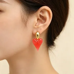 Close-up detail of a red resin heart earring with 18K gold plated stainless steel stud.