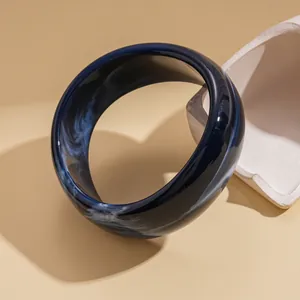 Macro view of elegant blue marbled resin bangle with a glossy finish and smooth edges
