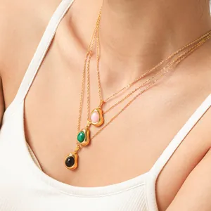 Close-up of layered 18K gold-plated stainless steel necklaces with stone bean pendants.