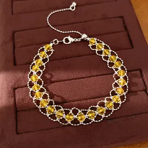 Détail d'un bracelet tissé en perles de verre jaunes avec fermoir coulissant argenté